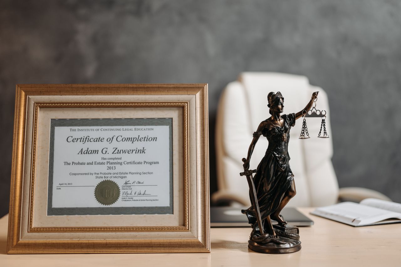 Crafting Captivating Headlines: Your awesome post title goes here A framed legal certificate and Lady Justice figurine on a desk in a law office setting.